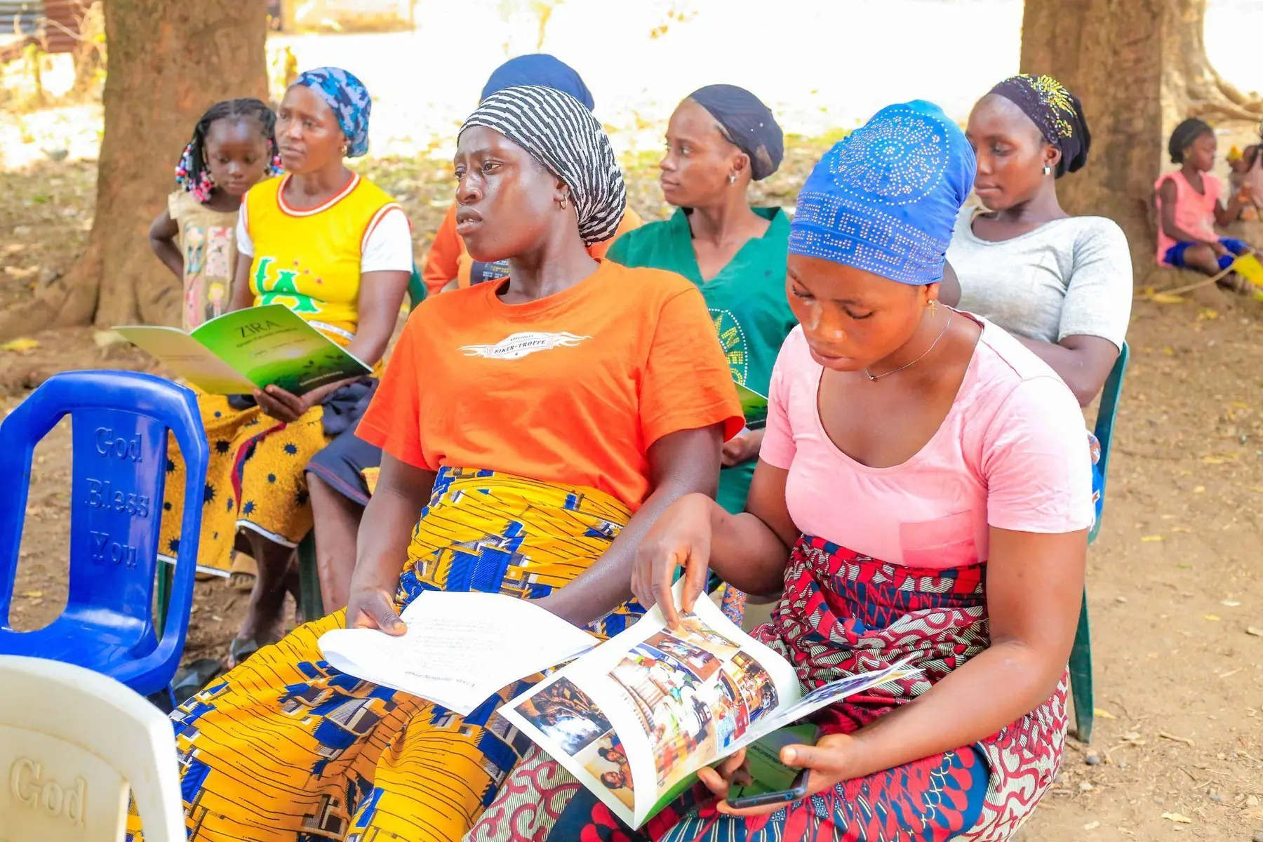 Women reviewing clean cooking information during the outreach