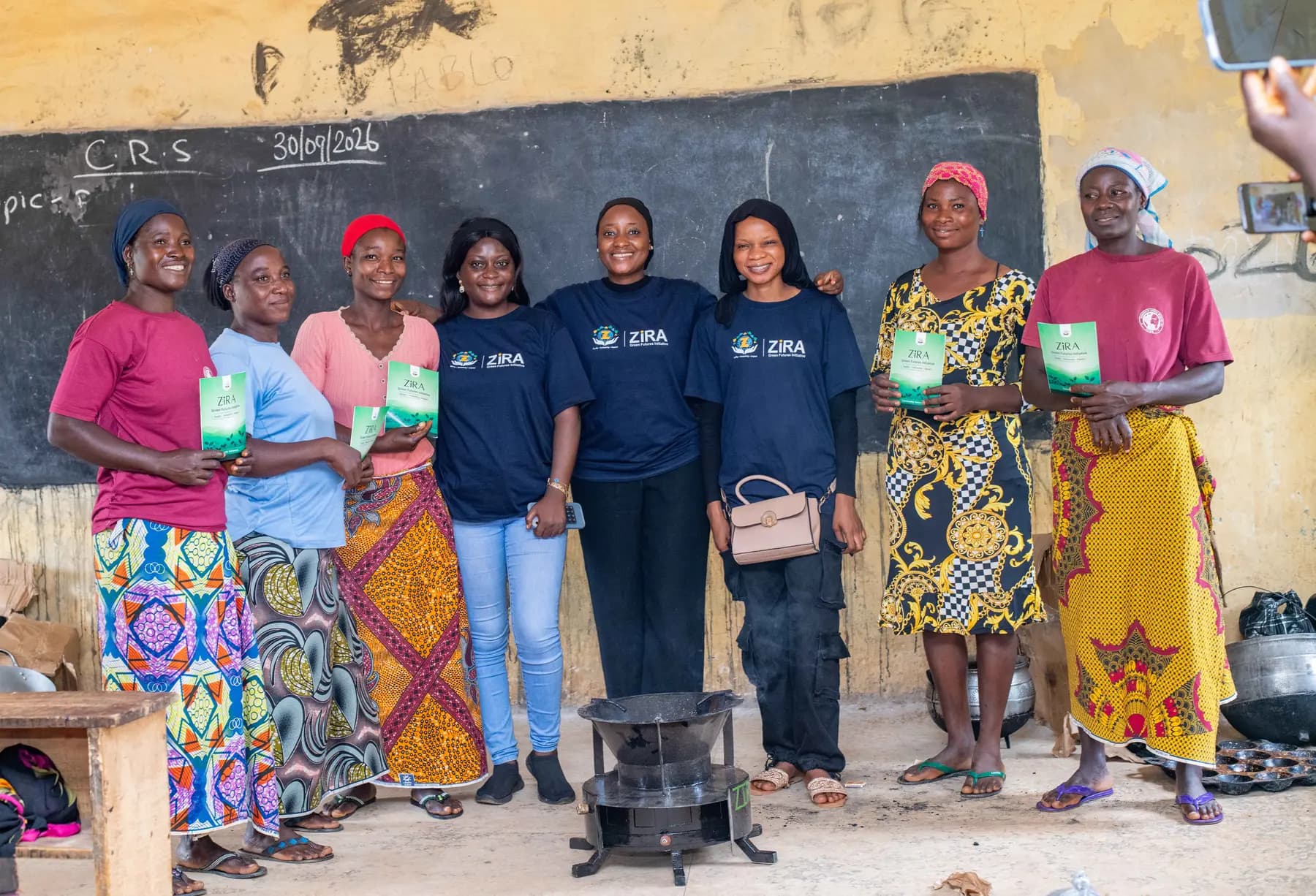 Community participants standing with a ZiRA clean cookstove