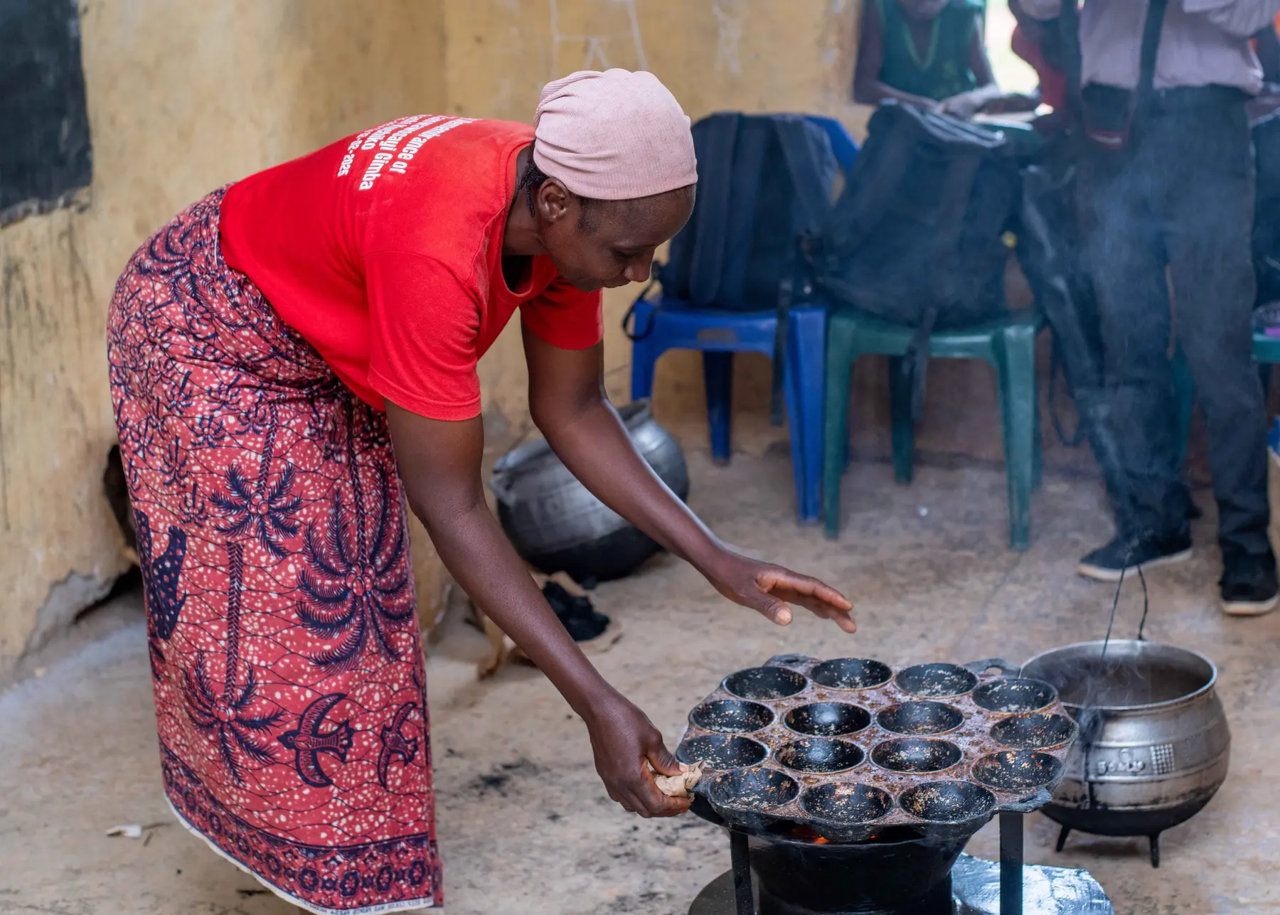 A woman preparing food with a ZiRA clean cookstove