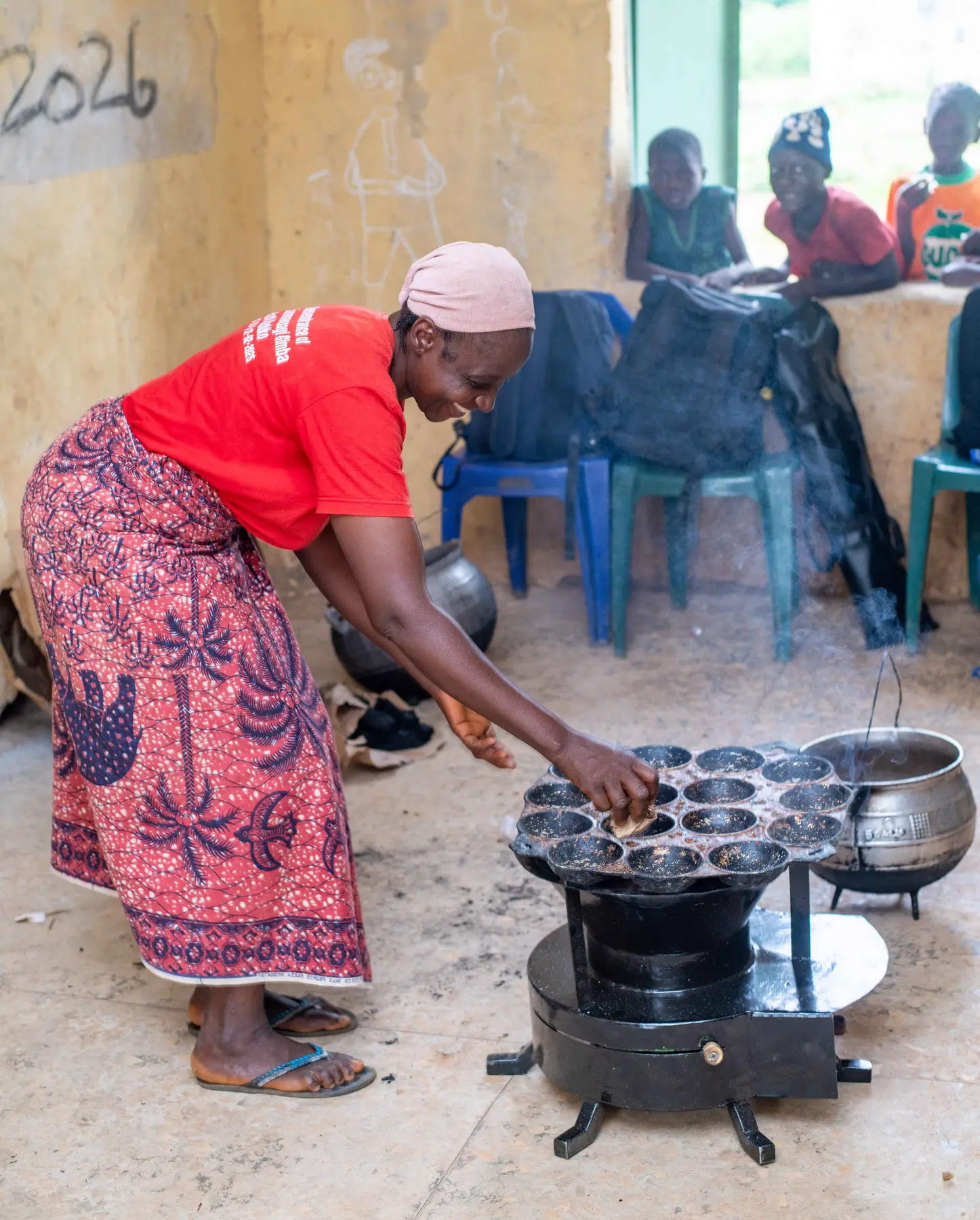 A woman demonstrating everyday cooking on a ZiRA stove